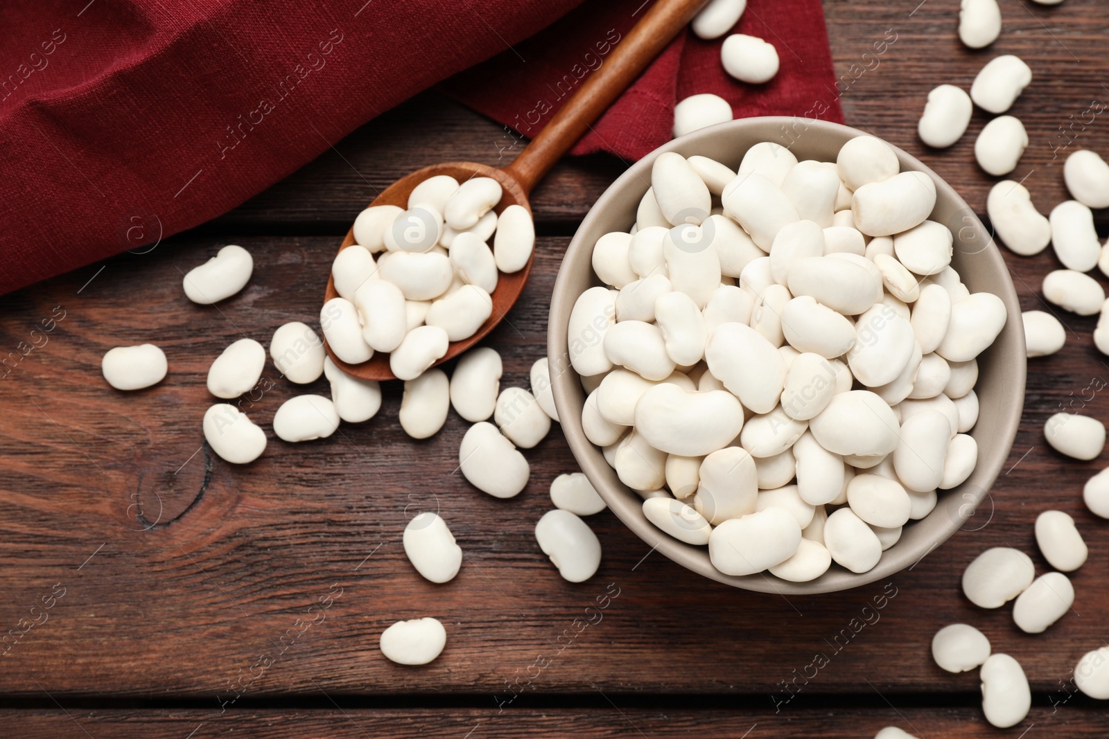 Photo of Raw white beans on wooden table, flat lay