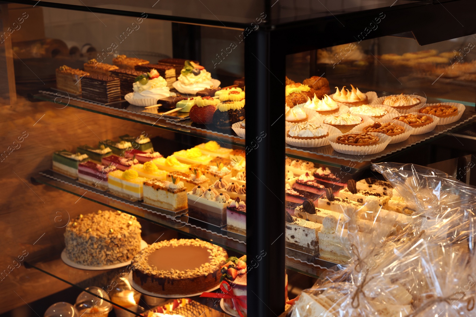 Photo of Counter with different tasty desserts in bakery shop