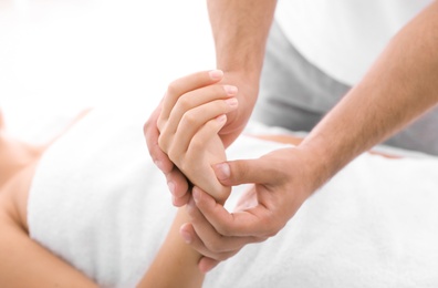 Photo of Young woman receiving massage in salon, closeup