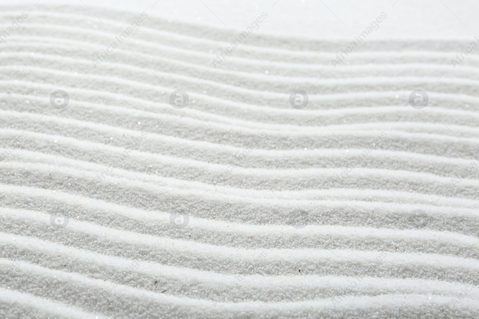 Photo of Zen rock garden. Wave pattern on white sand, closeup