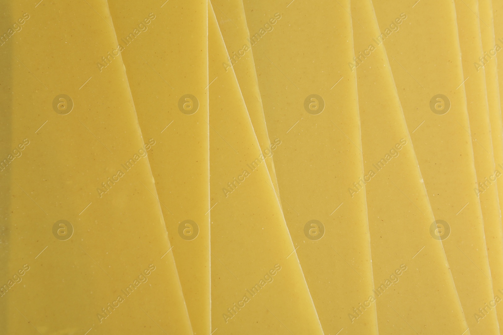 Photo of Pile of dry lasagna sheets as background, closeup