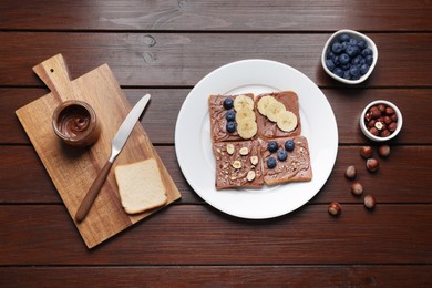 Photo of Different tasty toasts with nut butter and products on wooden table, flat lay