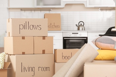 Photo of Cardboard boxes and household stuff in kitchen. Moving day