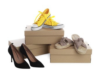 Different stylish shoes and cardboard boxes on white background