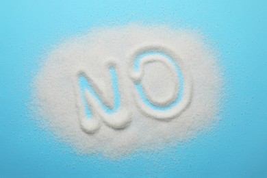 Photo of Word No made of sugar on light blue background, top view