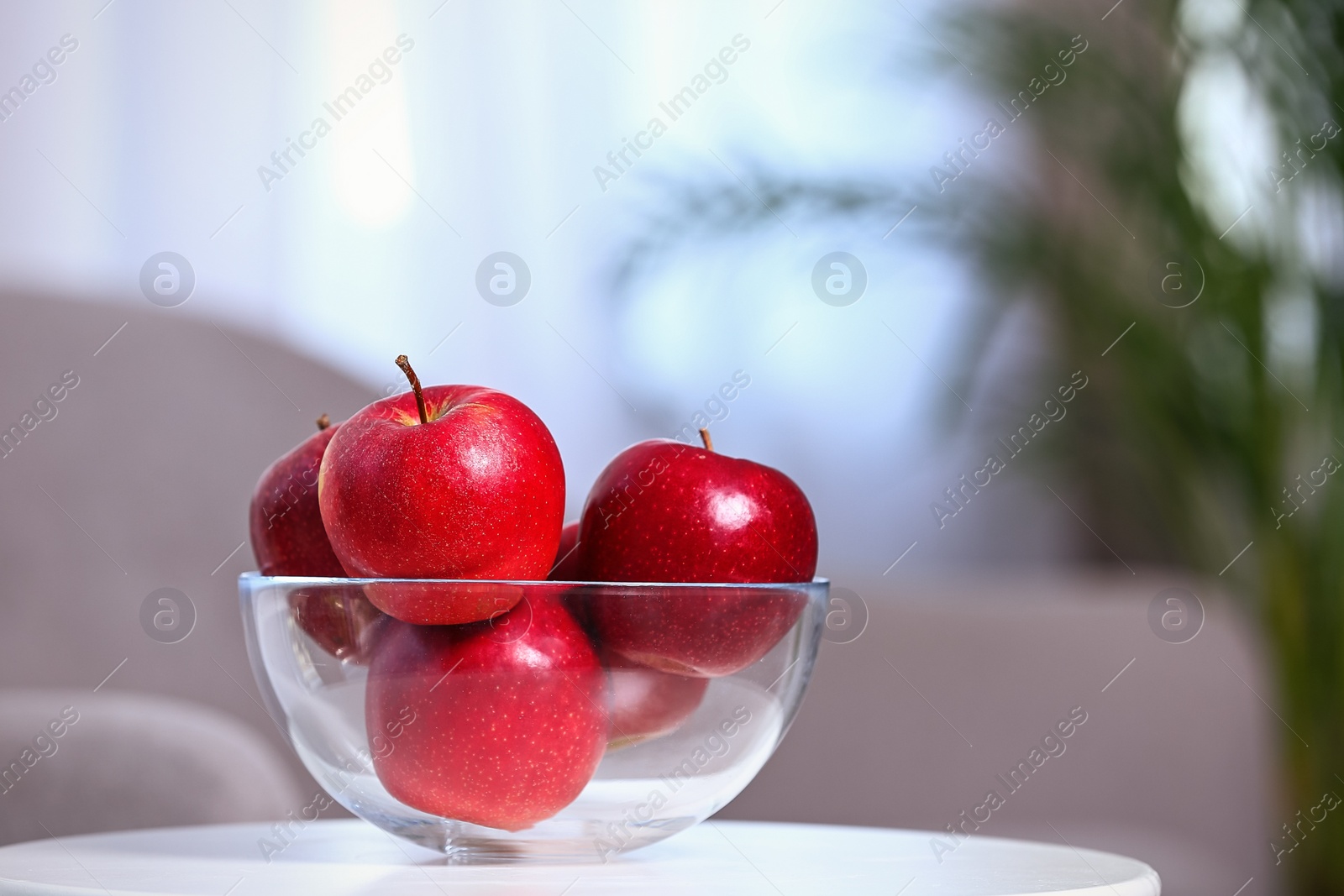 Photo of Bowl of fresh red apples on table indoors. Space for text