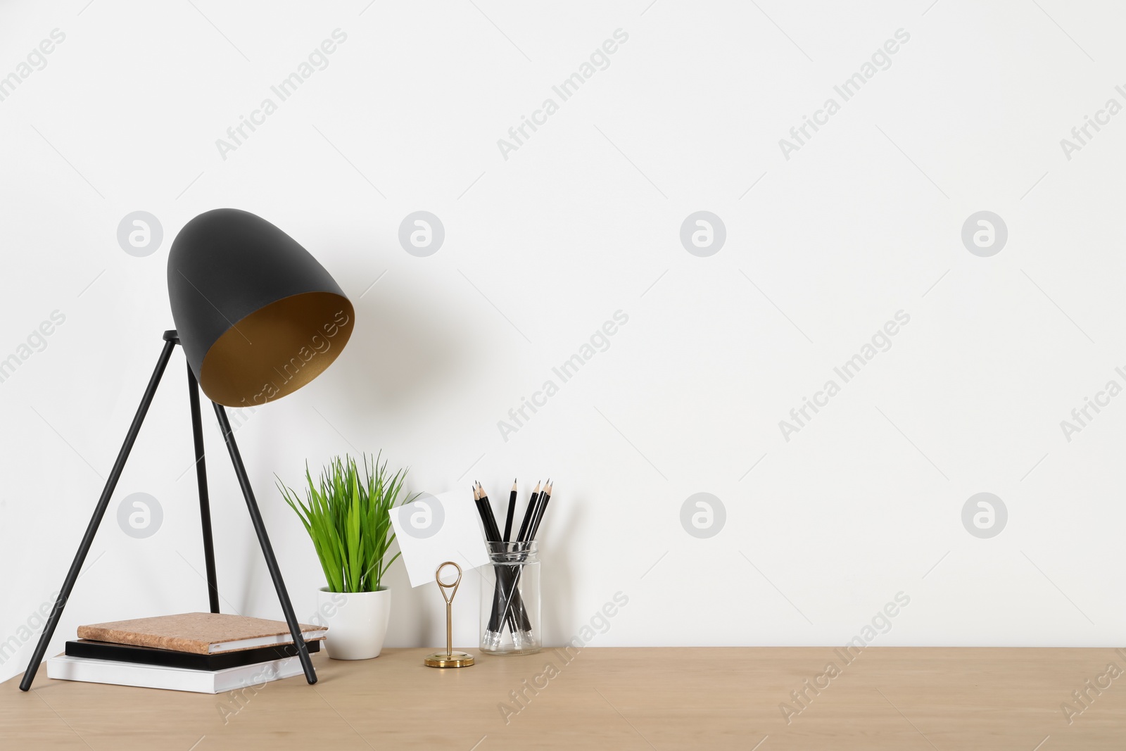 Photo of Comfortable workplace with wooden desk near white wall at home