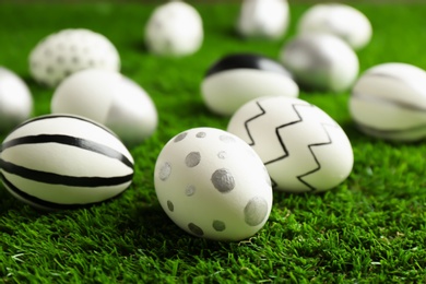 Traditional painted Easter eggs on green lawn, closeup