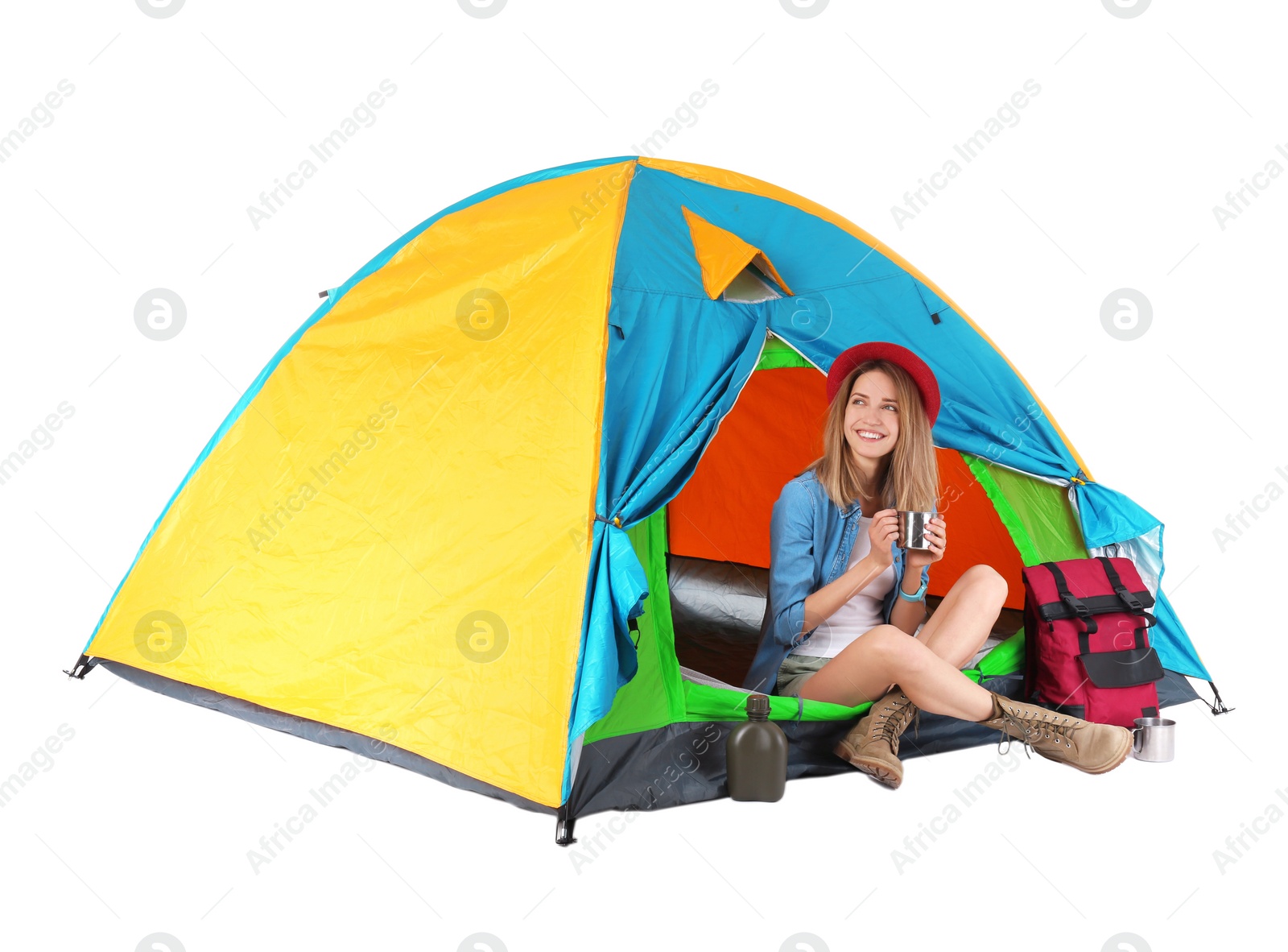 Photo of Young beautiful woman sitting in tourist tent on white background