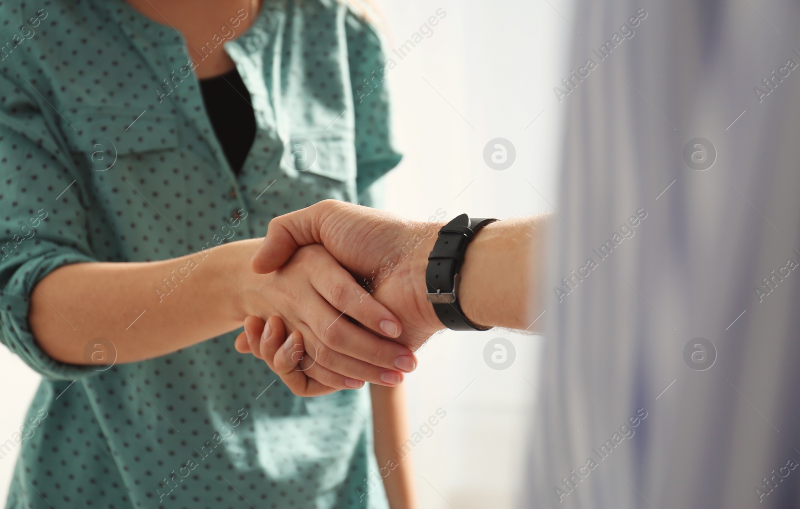 Photo of Man and woman shaking hands on light background, closeup. Help and support concept