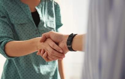 Photo of Man and woman shaking hands on light background, closeup. Help and support concept