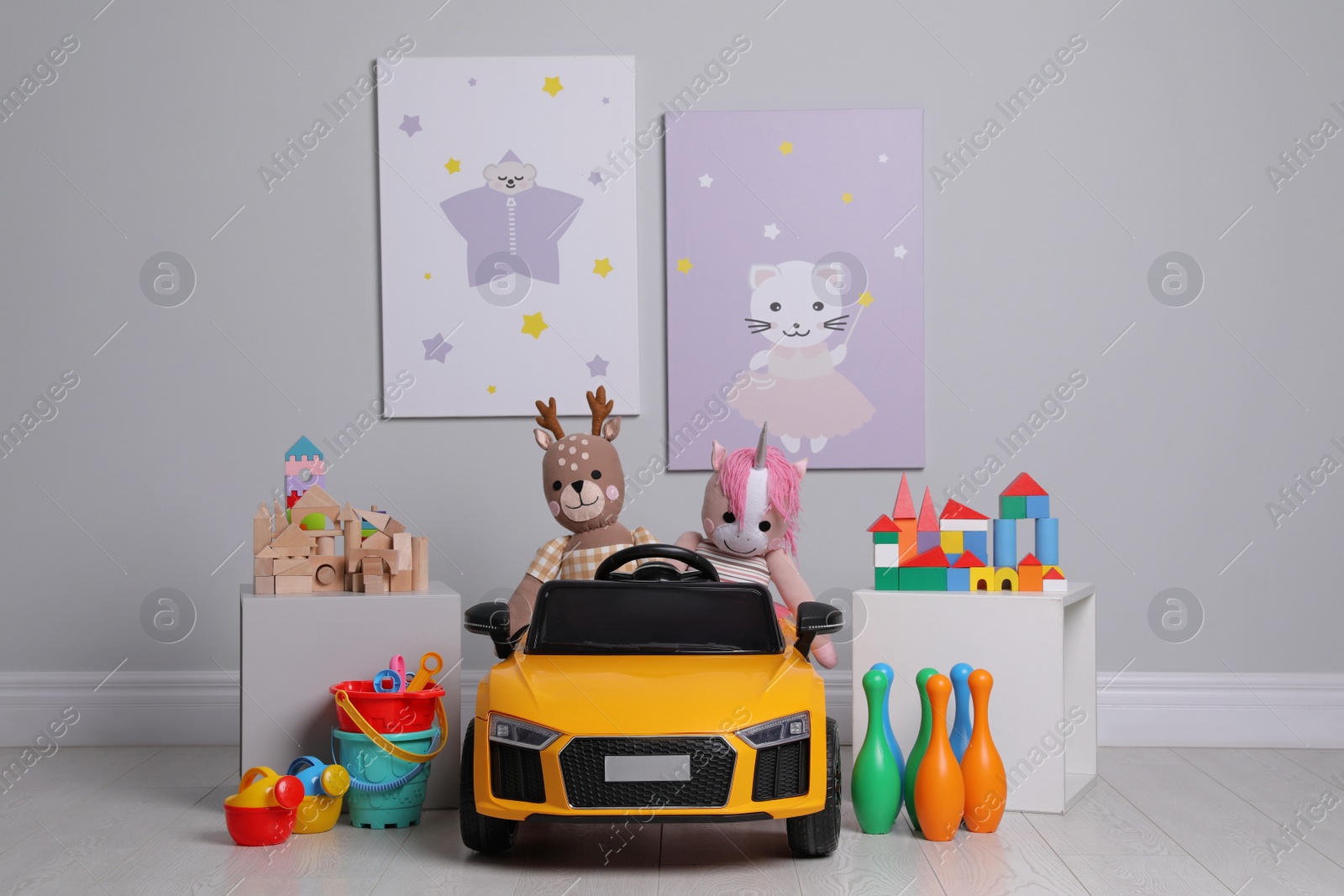 Photo of Child's electric car with other toys near light wall in play room