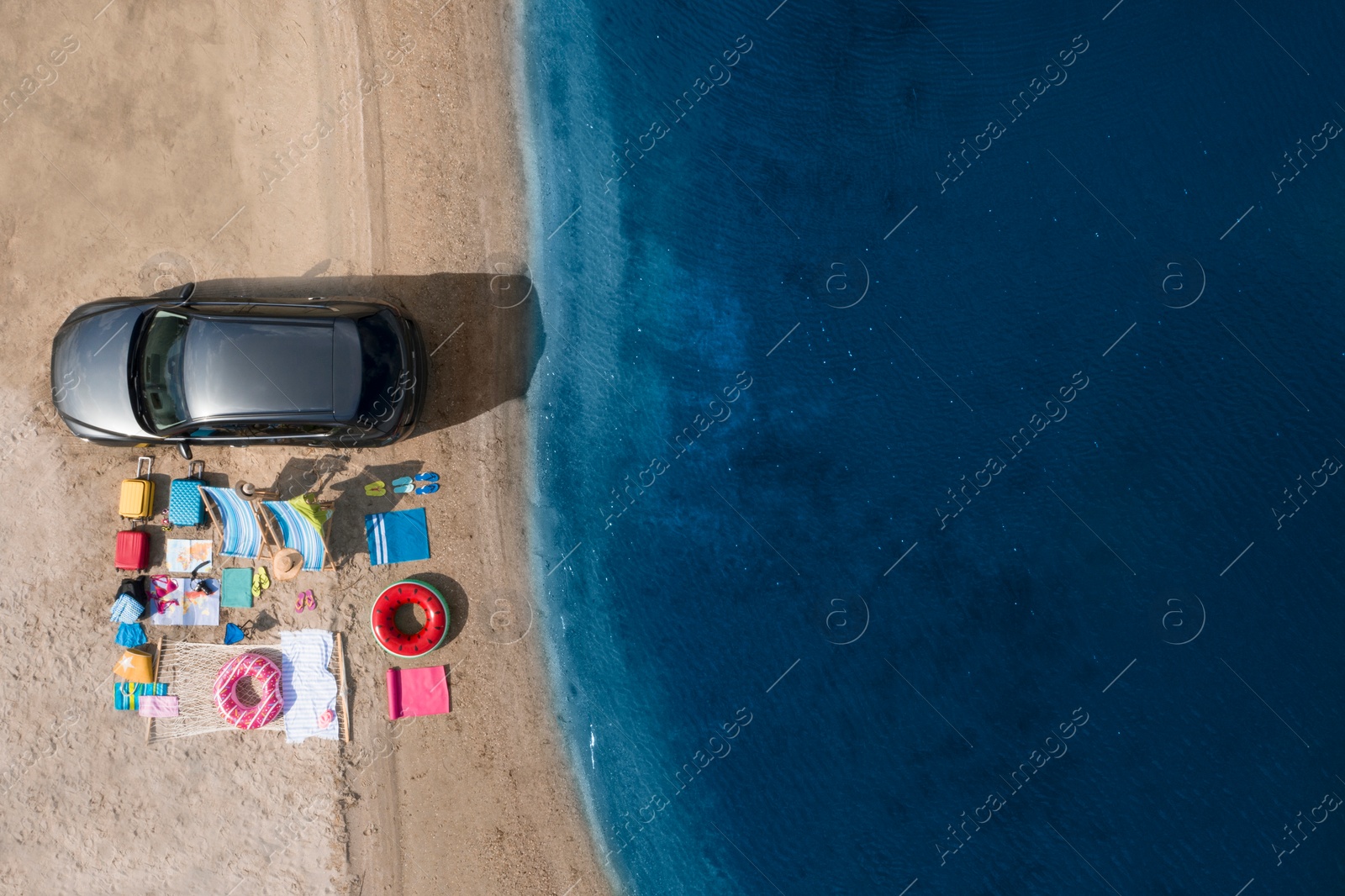 Image of Car and beach accessories on sand near river, aerial view. Summer trip