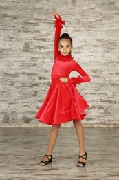 Beautifully dressed little girl dancing in studio