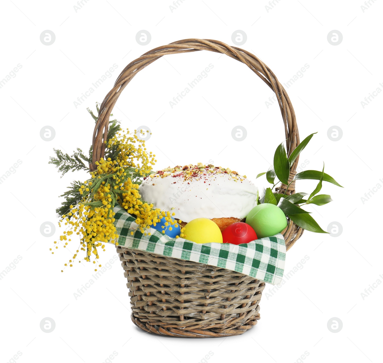 Photo of Basket with delicious Easter cake, dyed eggs and flowers on white background