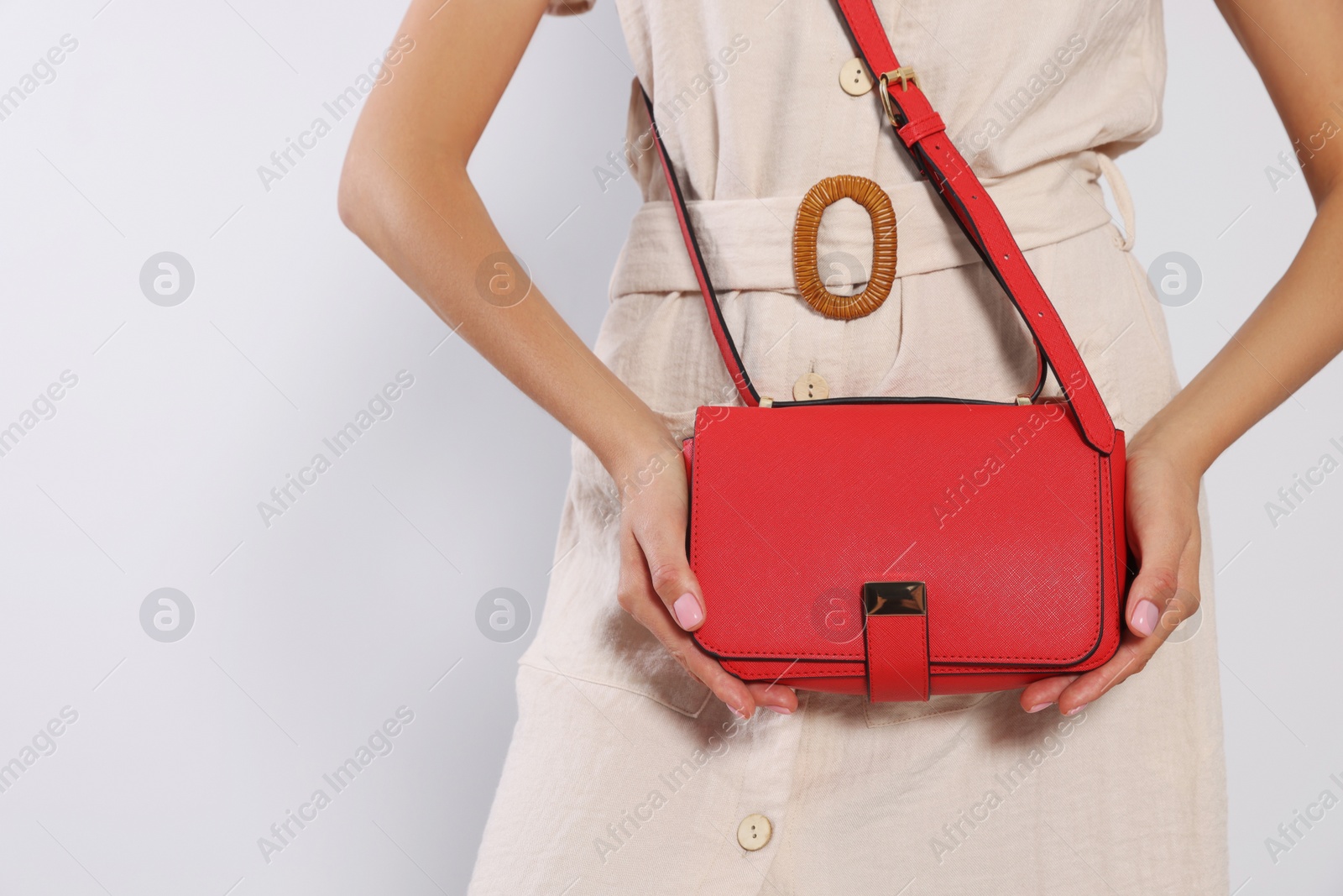 Photo of Woman with stylish red bag on light grey background, closeup