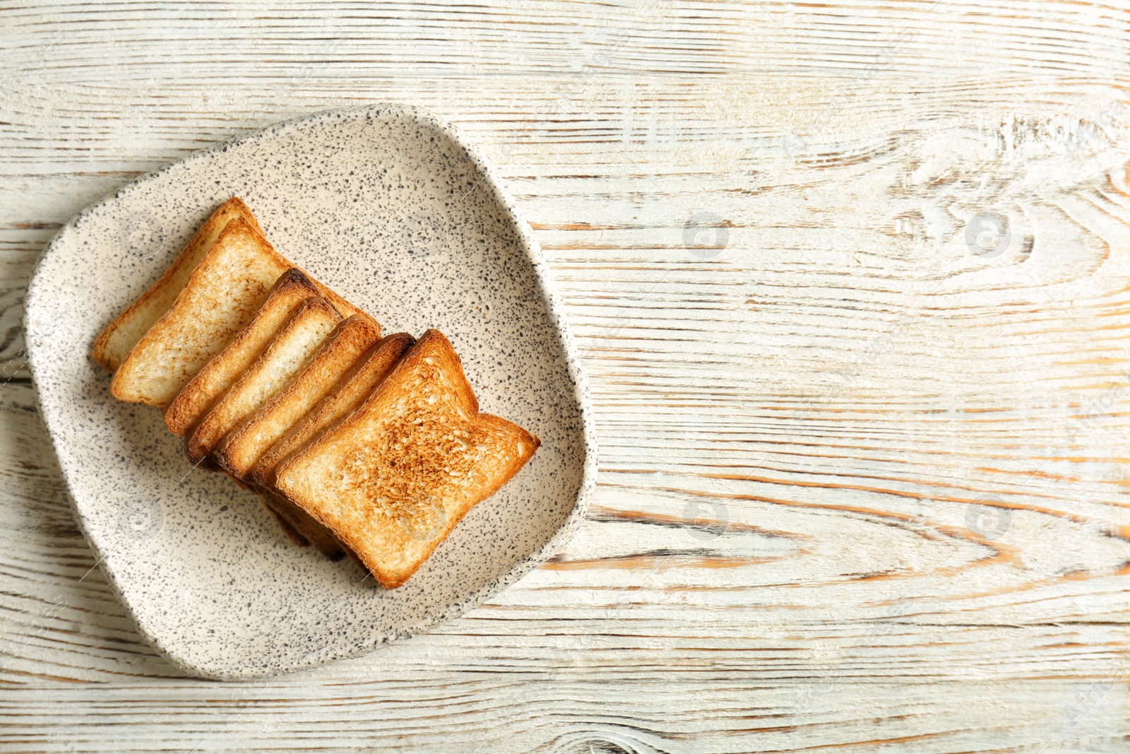 Photo of Plate with toasted bread on wooden background, top view