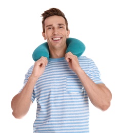 Photo of Happy young man with neck pillow on white background