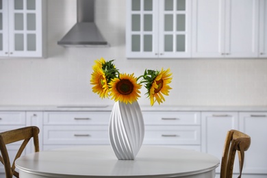 Bouquet of beautiful sunflowers on table in kitchen