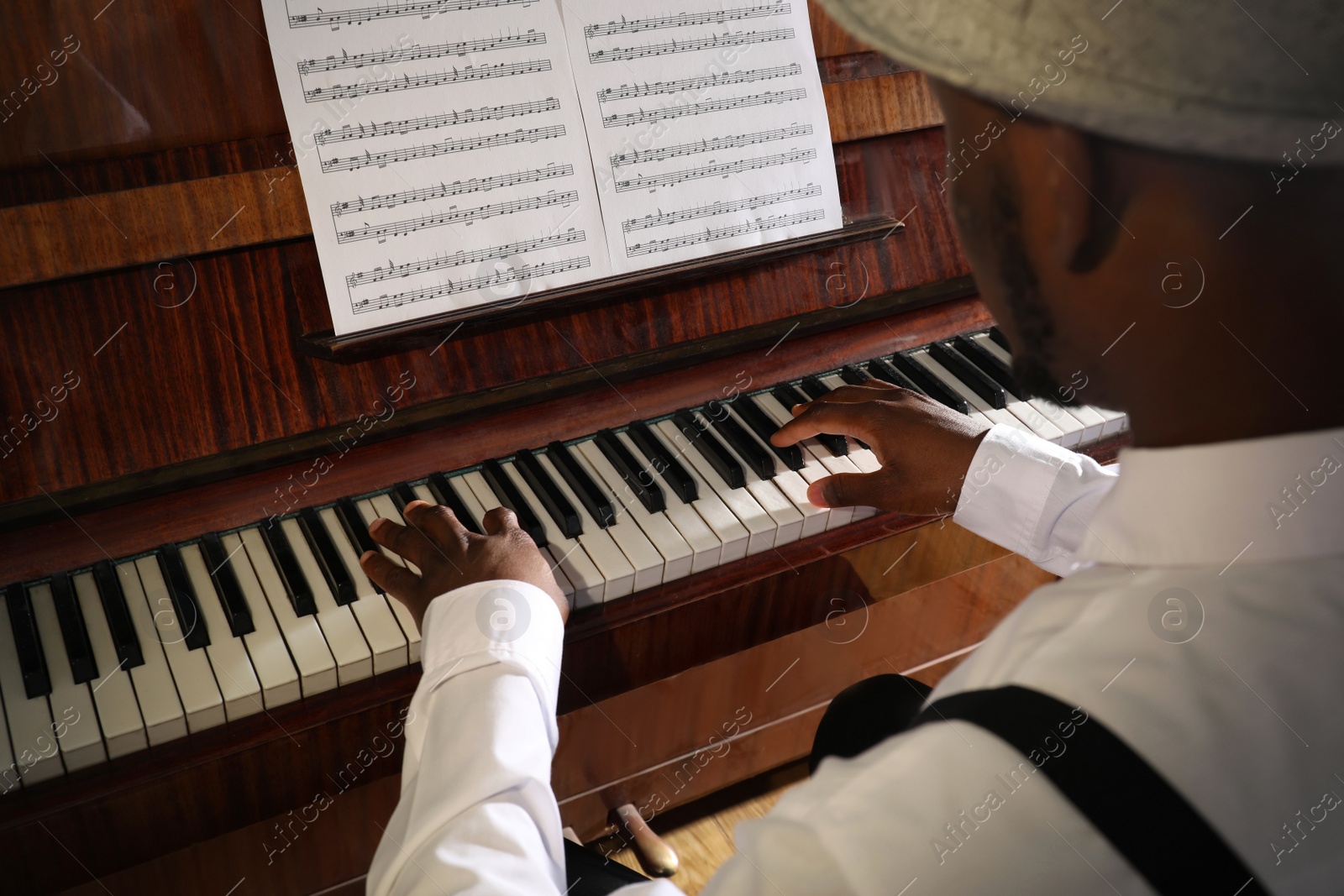 Photo of African-American man playing piano, closeup. Talented musician