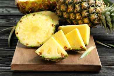 Photo of Fresh sliced pineapple on wooden board, closeup