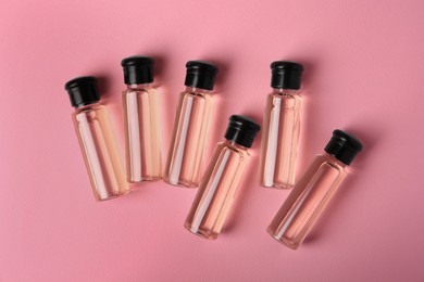 Photo of Bottles of cosmetic products on pink background, flat lay