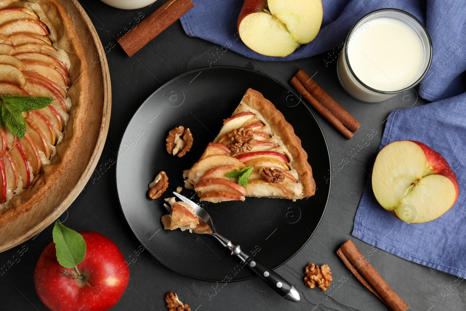 Photo of Delicious apple pie served on black table, flat lay