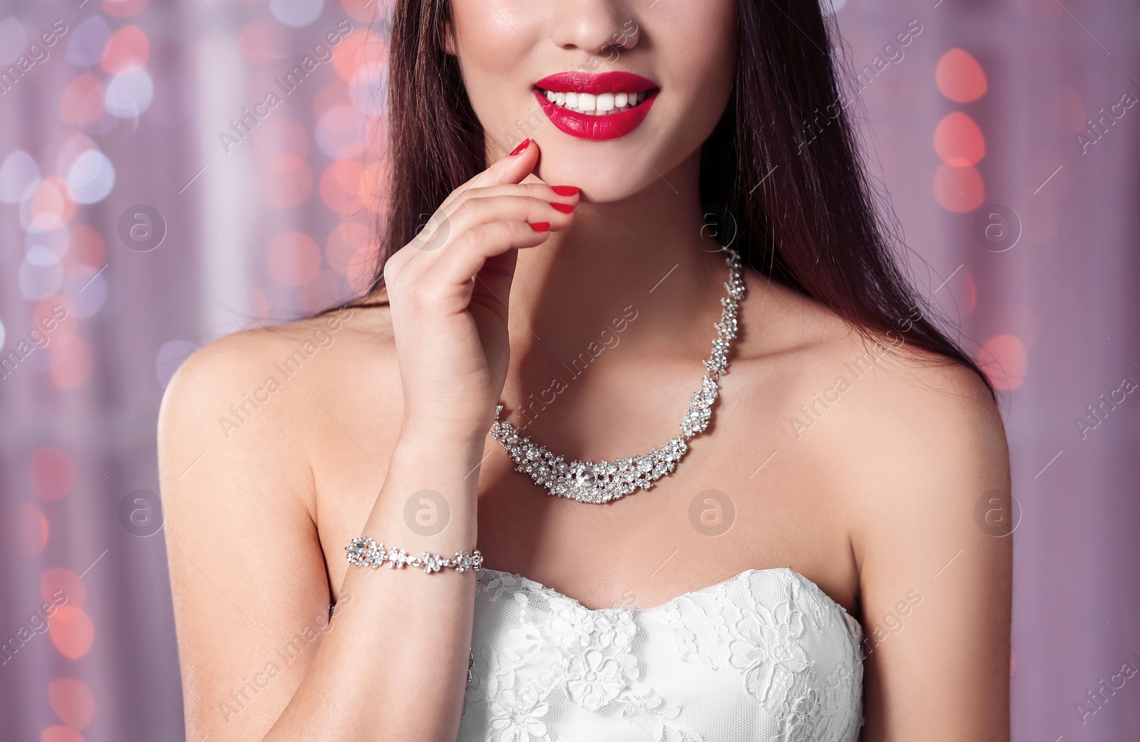 Photo of Beautiful woman with stylish nail polish against blurred lights, closeup