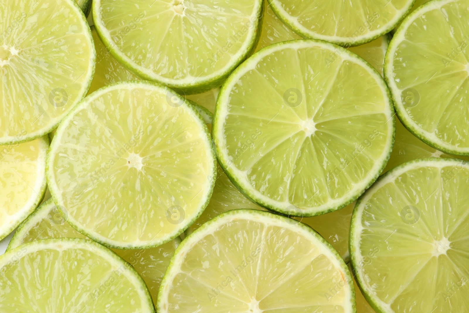 Photo of Fresh juicy lime slices as background, top view