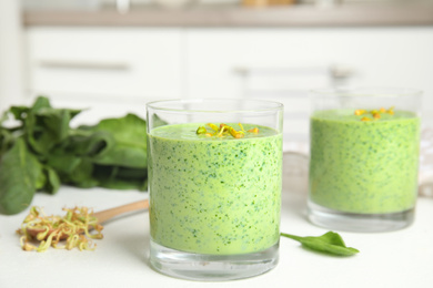 Photo of Green buckwheat smoothie on white table, closeup