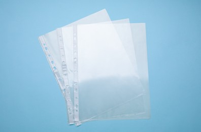 Photo of Empty punched pockets on turquoise background, flat lay