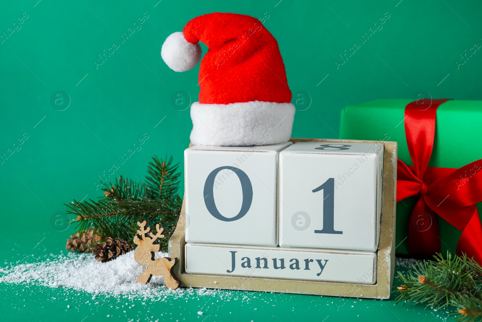 Photo of Block calendar and Christmas decor on green background. New Year celebration