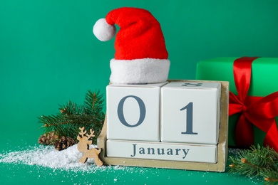 Photo of Block calendar and Christmas decor on green background. New Year celebration