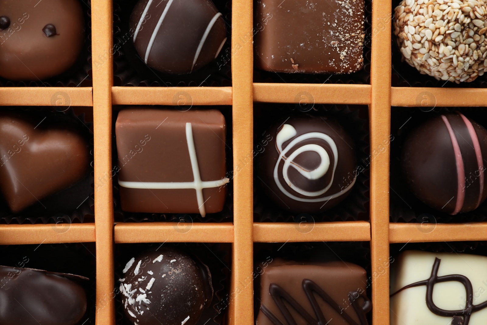 Photo of Box with different chocolate candies as background, top view