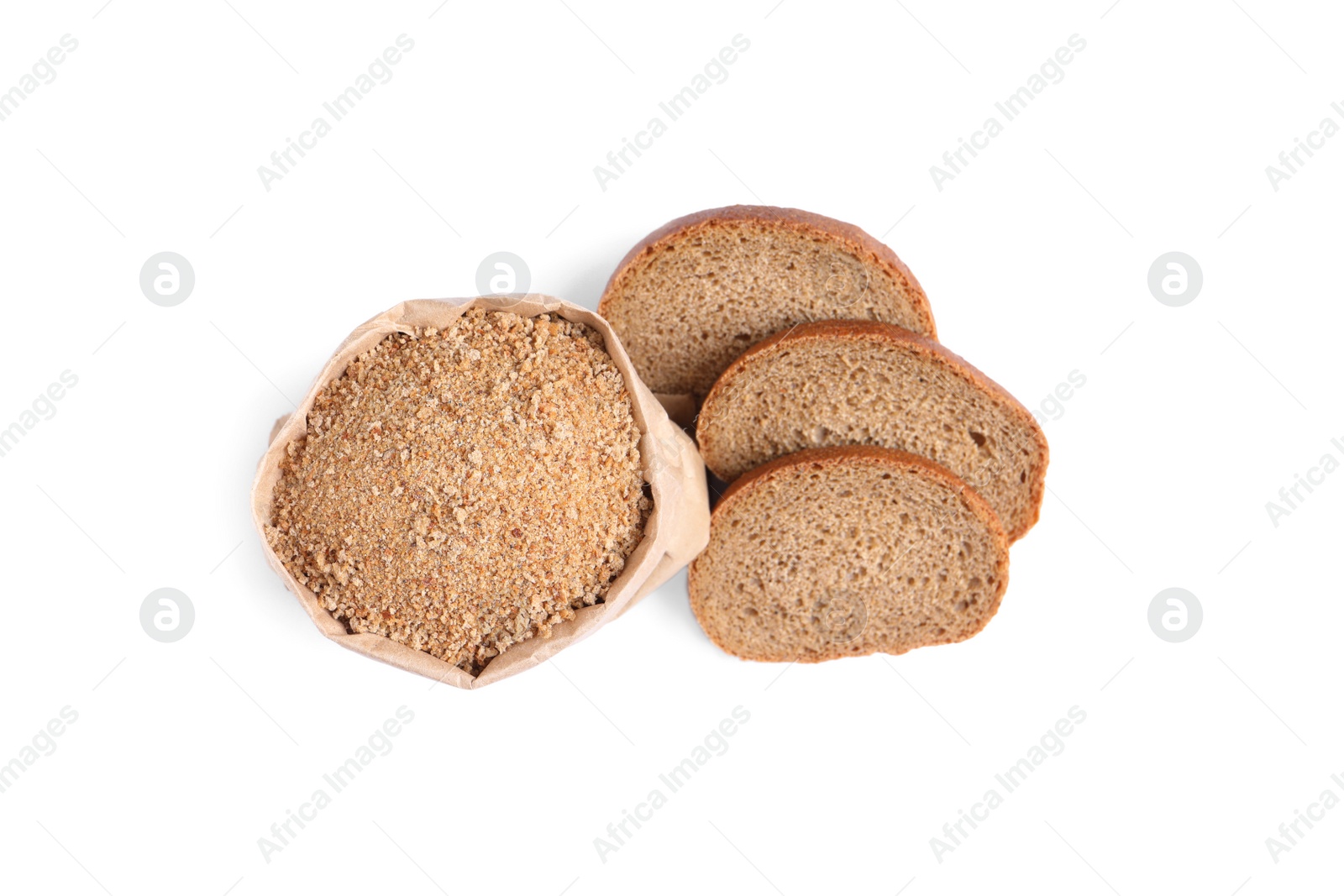 Photo of Fresh bread crumbs in paper bag and slices of loaf on white background, top view