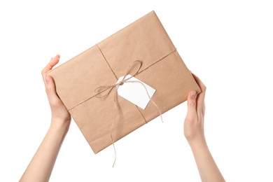 Photo of Woman holding parcel wrapped in kraft paper with tag on white background, closeup