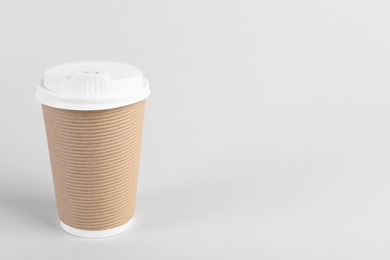 Paper cup with plastic lid on light background, space for text. Coffee to go