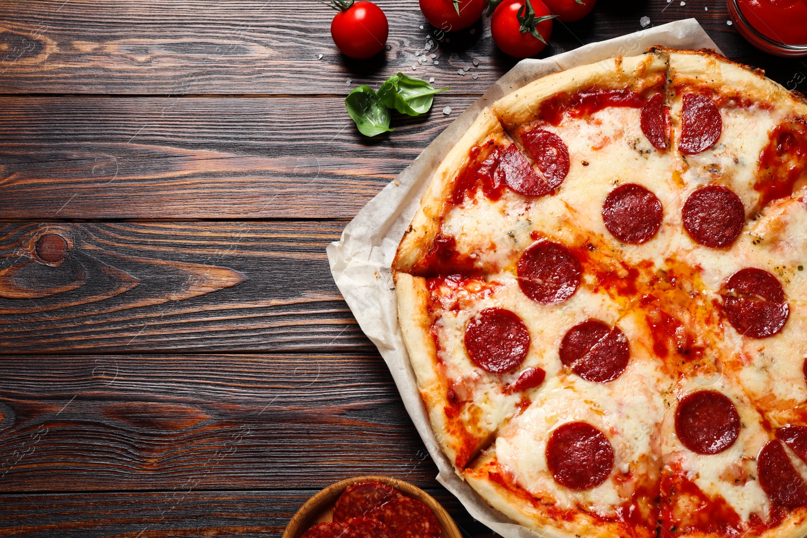 Photo of Flat lay composition with hot pepperoni pizza on wooden table. Space for text