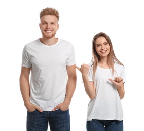 Photo of Young couple wearing blank t-shirts isolated on white. Mockup for design