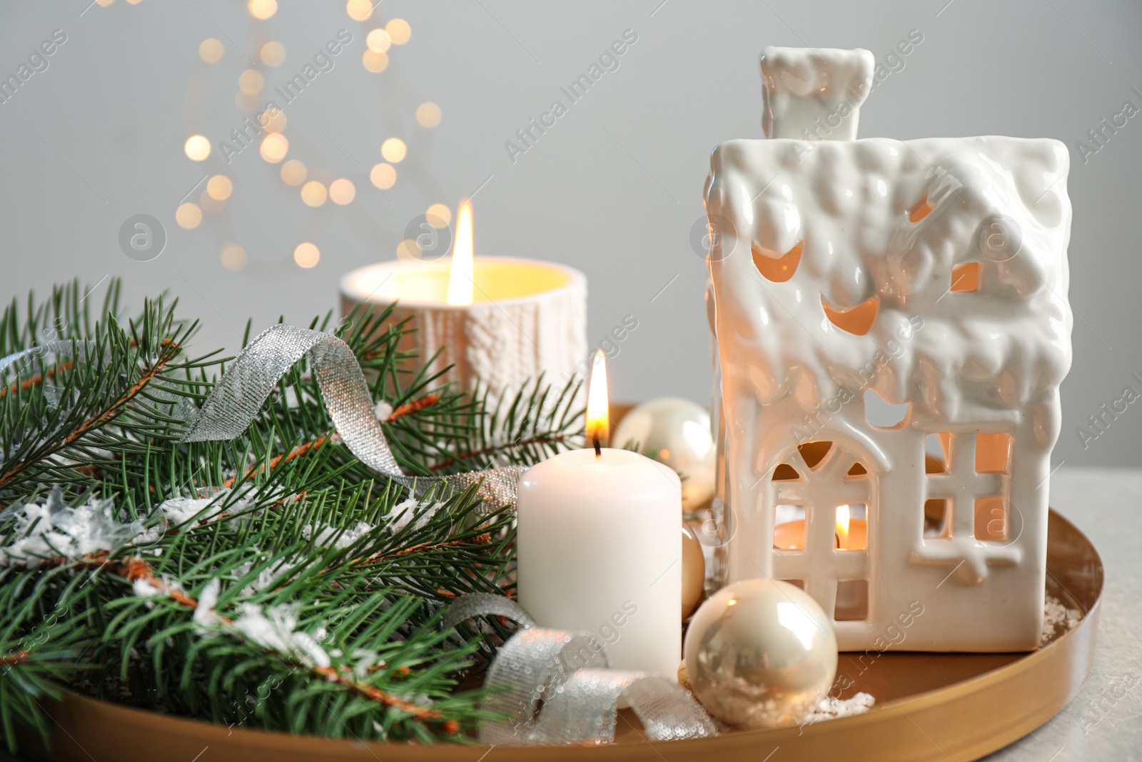 Photo of Composition with house shaped candle holder on grey table against blurred background. Christmas decoration