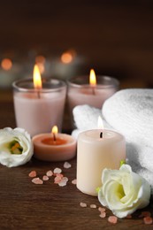 Beautiful spa composition with burning candles and flowers on wooden table