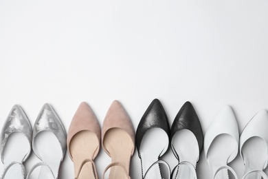 Photo of Many stylish female shoes on white background, top view
