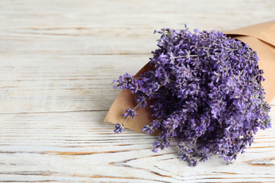 Beautiful lavender bouquet on white wooden table, closeup. Space for text