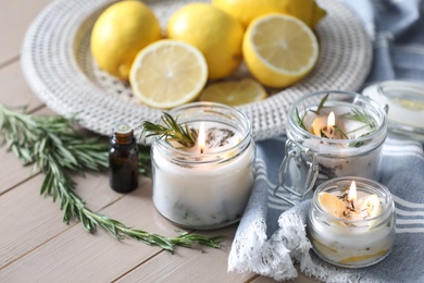 Photo of Natural homemade mosquito repellent candles and ingredients on wooden table