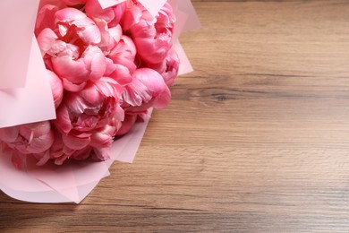 Bouquet of beautiful pink peonies on wooden table, closeup. Space for text