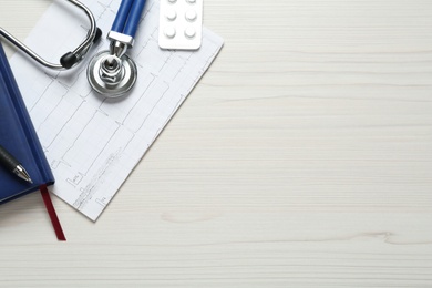Photo of Flat lay composition with cardiogram report and stethoscope on white wooden background, space for text
