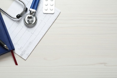 Flat lay composition with cardiogram report and stethoscope on white wooden background, space for text