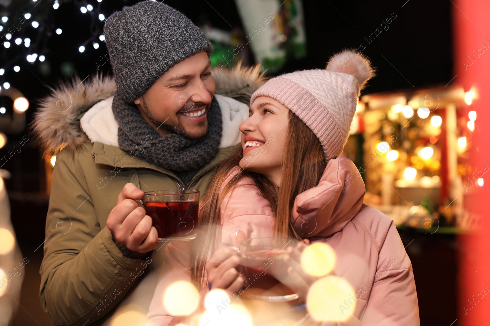 Photo of Happy couple with mulled wine at winter fair