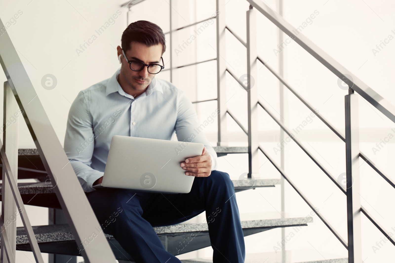 Photo of Portrait of young man with laptop indoors
