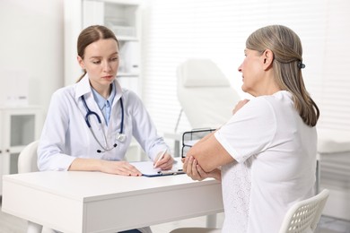 Photo of Arthritis symptoms. Doctor examining patient's elbow in hospital